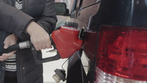 a woman fills up her car