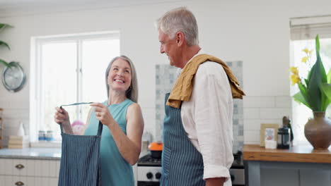 una pareja de mayores cocinando juntos.