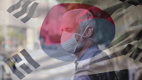 animation of flag of south korea waving over caucasian man wearing face mask in city street