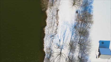 Volando-A-Lo-Largo-De-La-Orilla-De-Un-Río-Congelado-Después-De-Una-Tormenta-De-Nieve