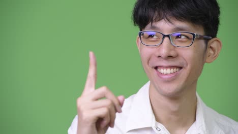 젊은 행복한 아시아 사업가가가 손을 들고 생각하고 있다.