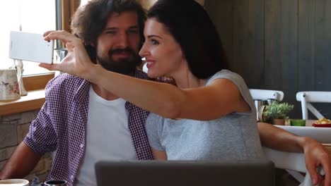 pareja tomando selfies desde el teléfono móvil
