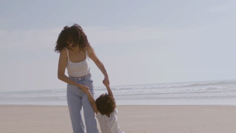 Feliz-Madre-Y-Dos-Niños-Pasando-Tiempo-En-La-Orilla-Del-Mar-En-Un-Día-Soleado-1