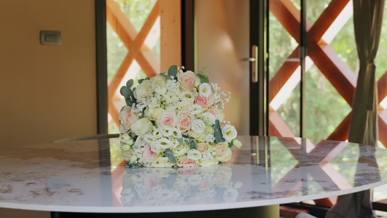 Hermoso ramo de novia de rosas blancas preparado sobre una mesa