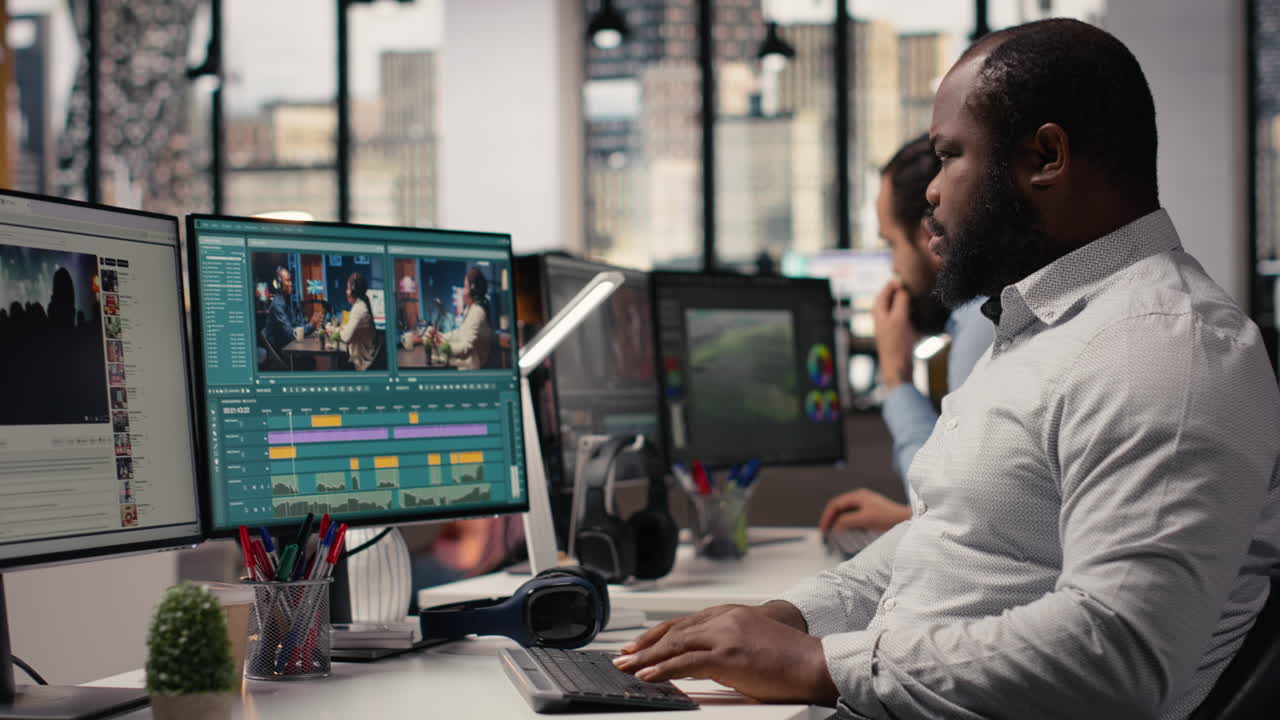 Black videographer editing raw video footage and adjusting sliders on software