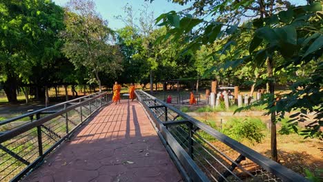 los monjes se pasean por un puente en la naturaleza