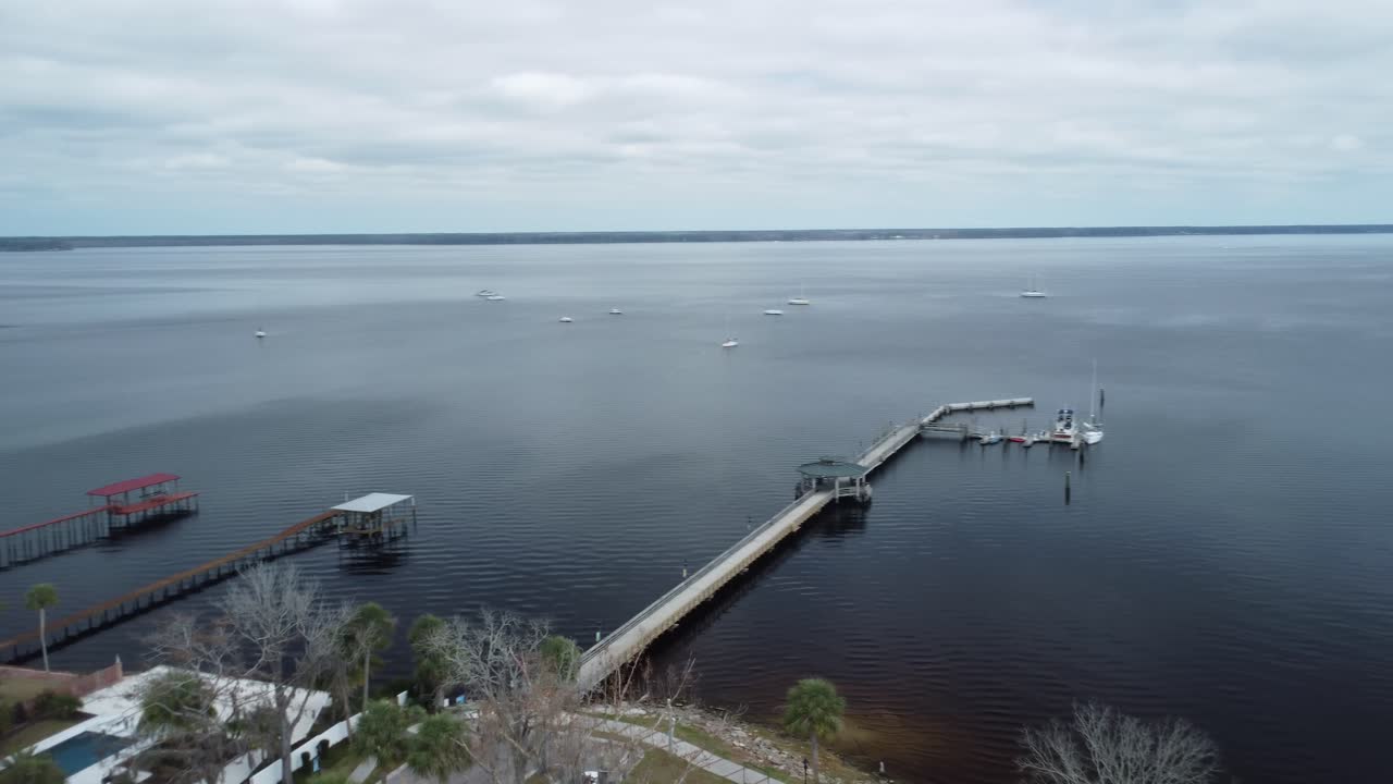 A breathtaking drone shot soars over a river pier, capturing calm waters, scenic views, and the peaceful rhythm of nature.