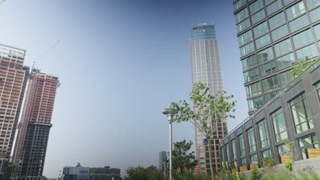 Rising-opposite-two-towering-skyscrapers,-a-high-rise-apartment-building-takes-its-place