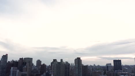 aerial footage tilts down in a reverse reveal of the manhattan new york city skyline and the fdr drive full of traffic