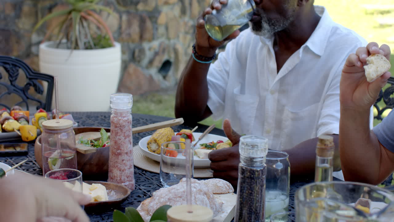 Senior diverse men enjoying in garden lunch, sharing stories and laughter in garden setting