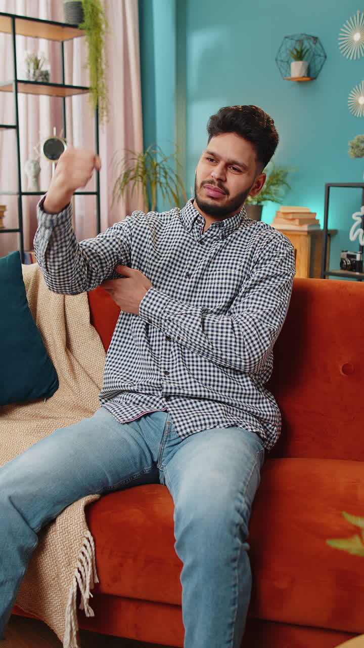 joven indio hombre experimentando dolor e incomodidad en la articulación del codo del brazo y masajeando la mano dolorosa