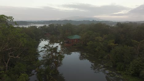 low flying over wooden houses on dulce river at guatemala, aerial