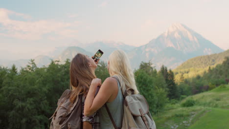 two women hiking and taking photos of mountains