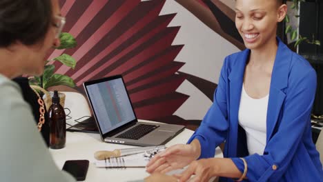 Happy-diverse-woman-and-seller-paying-with-credit-card-in-jewellery-shop-in-slow-motion