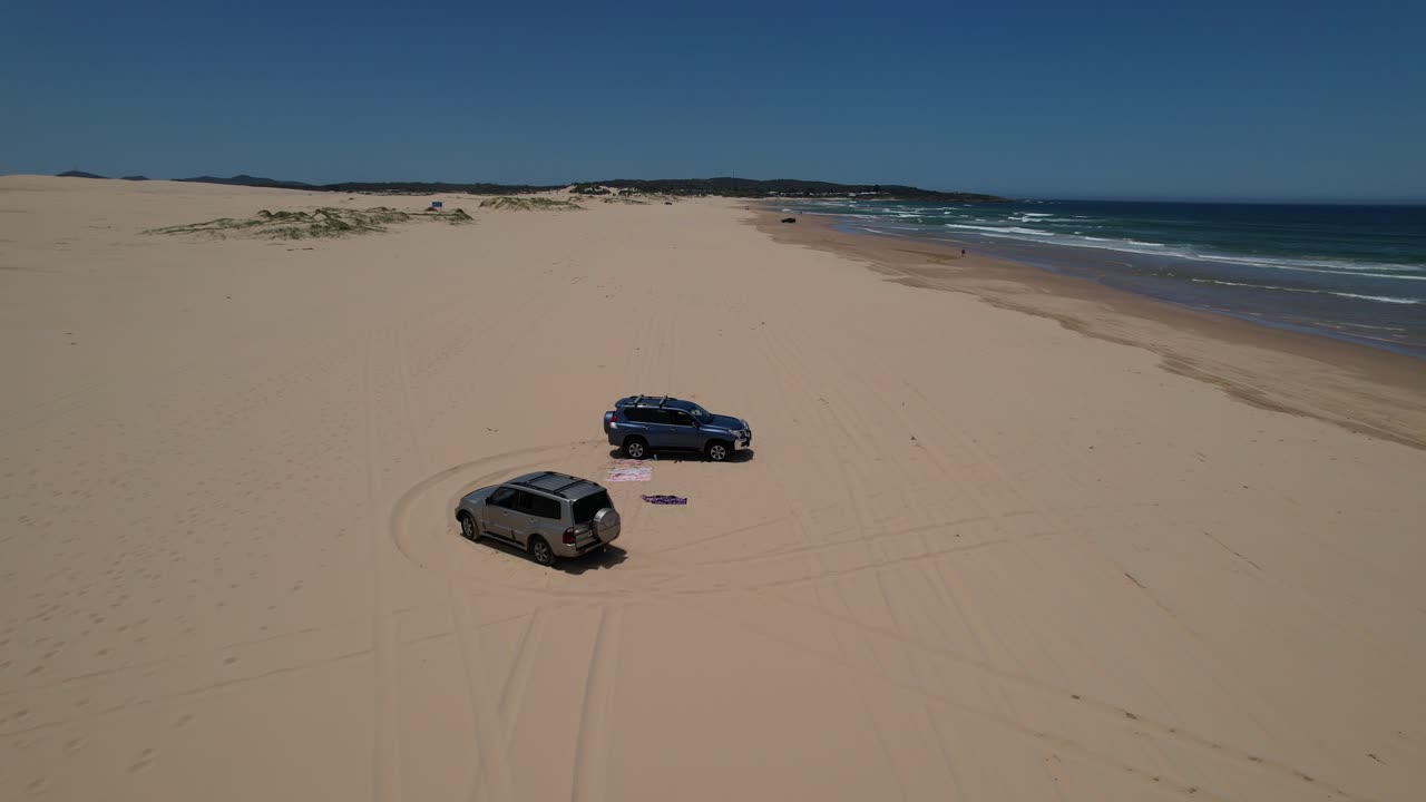 4WD Vehicles Parked On Sand Dunes Of Stockton Beach In Anna Bay, NSW, Australia. aerial flyby shot
