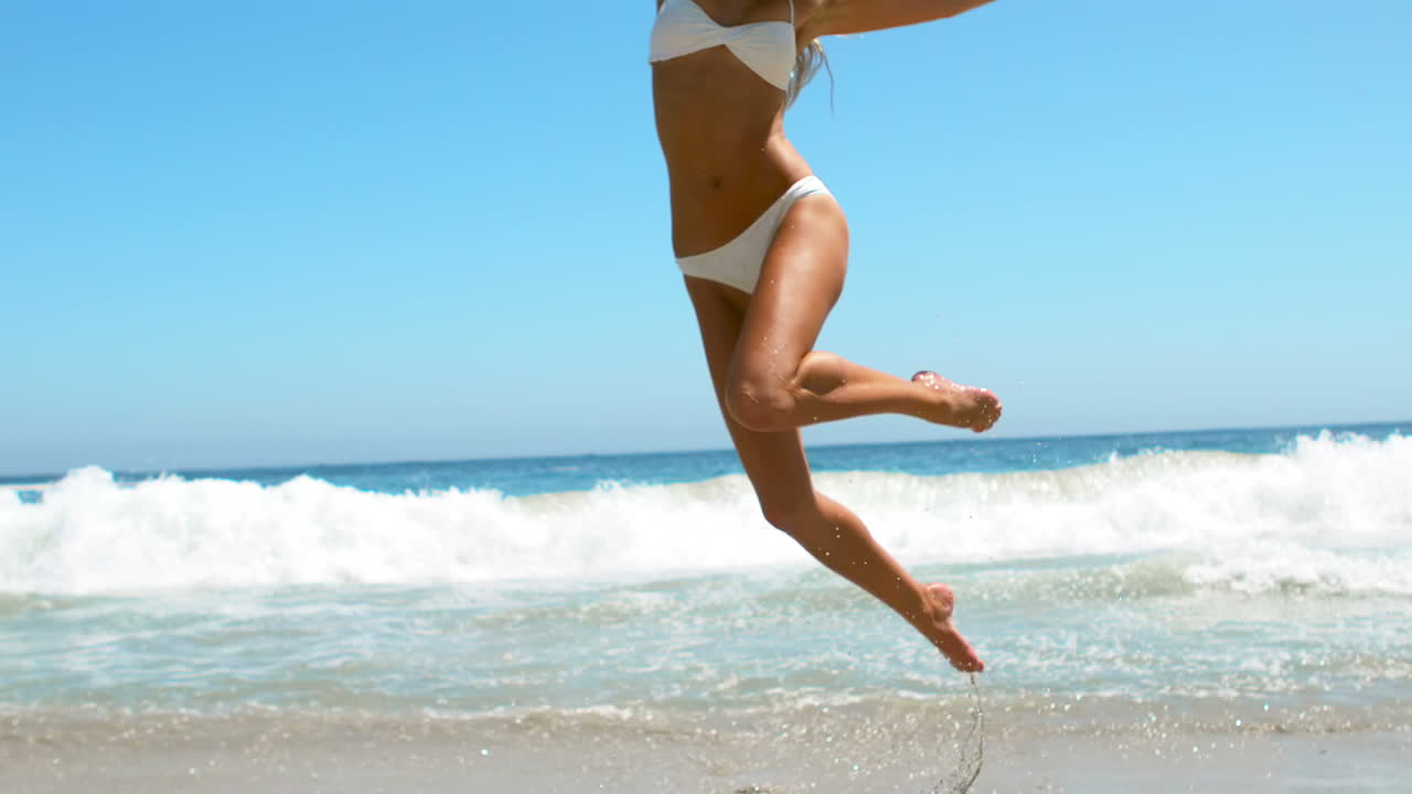 Donna che salta in spiaggia
