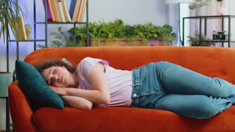 Tired-lazy-woman-enjoy-relaxing-on-home-sofa-resting-napping-after-hard-working-day,-closed-her-eyes