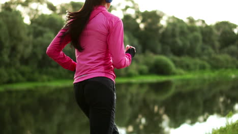 close-up of feet running in sneakers along the river on the grass