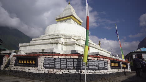 buddhist stupa in everest region where trekkers practice korra meditation rituals buddhist flags flutter under cloudy skies serene atmosphere in high-altitude mountainous landscape of the himalayas