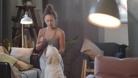 mujer entrenando a su golden retriever en casa