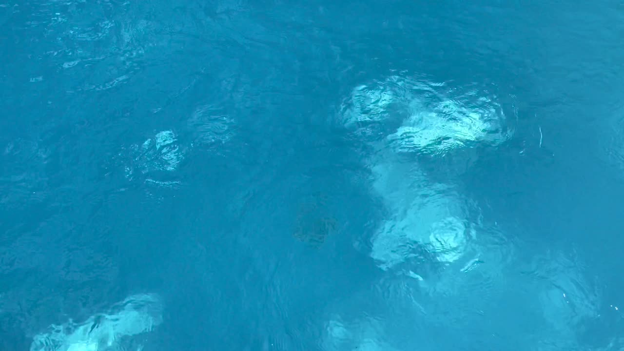 4k의 야외 수영장 바닥에 있는 작동하는 물 필터의 상위 뷰