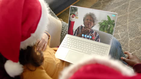una pareja feliz y una madre anciana teniendo una llamada de video de navidad, cámara lenta.