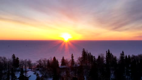 a beautiful sunrise overlooking the shoreline of a frozen winter landscape