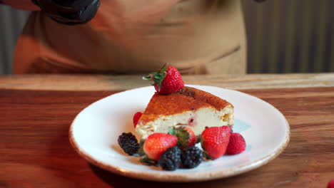 el chef arroja bayas aplastadas a la tarta de queso