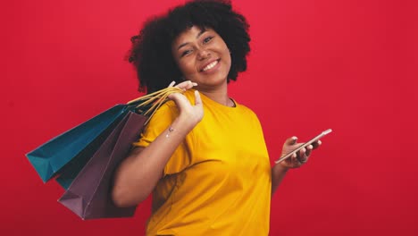 feliz mujer africana sonriente sosteniendo anillo de goma flamenco y disfrutando de sus vacaciones de verano.joven mujer afroamericana aislada en fondo rojo de color en vacaciones con viajes.