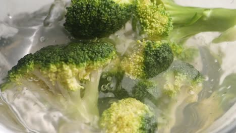 broccoli being washed in water