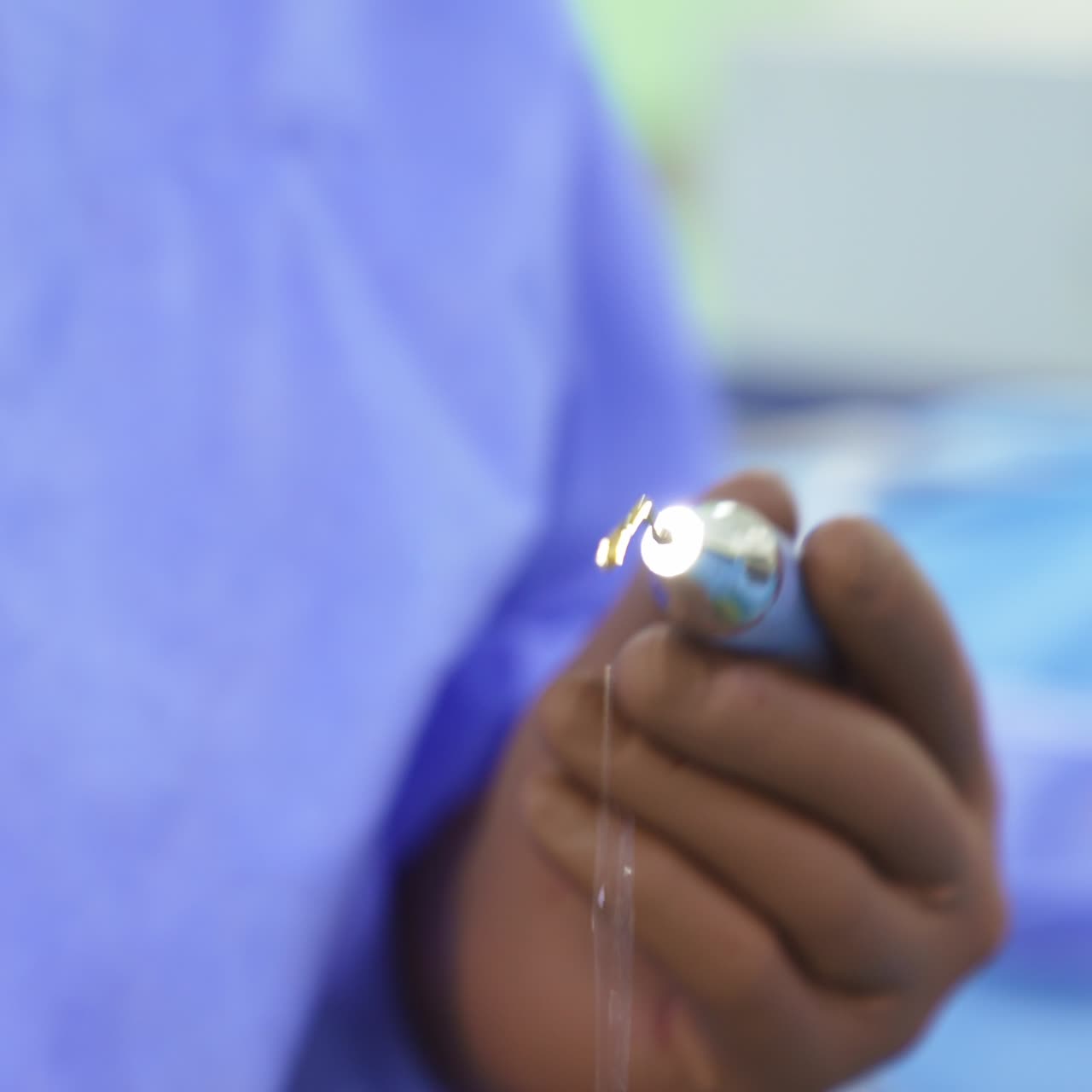 Surgical device in doctor's gloved hand. Special device with light and liquid gap for endonasal otolaryngology operations. Close up