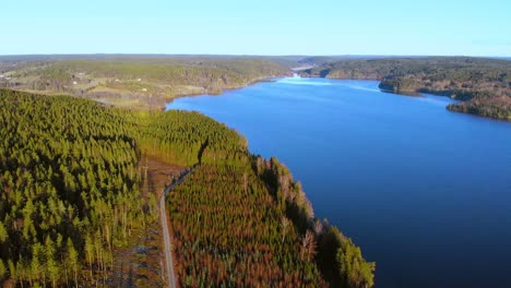 Birds-eye-view-over-dense-green-nature-reserve-around-beautiful-lake-on-an-unexplored-land