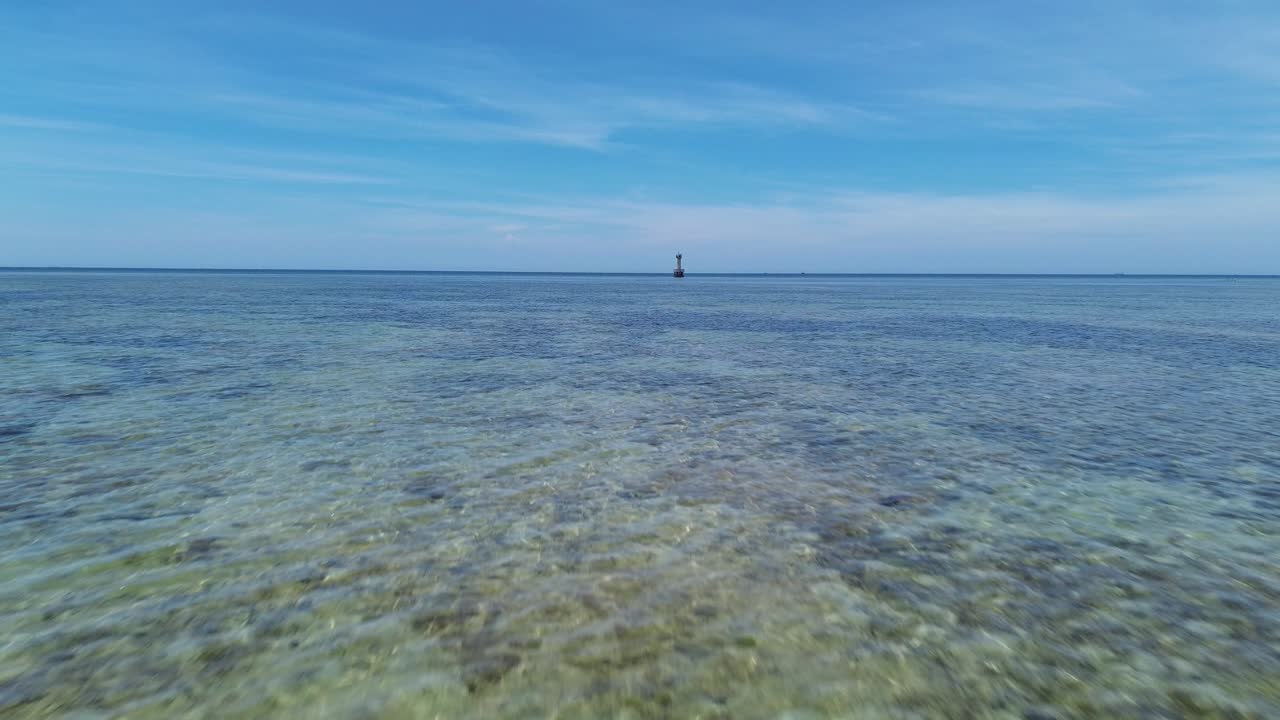 High-speed drone forward shot over shallow coral formations in My Hoa Lagoon, framed by bright daylight and clear skies.