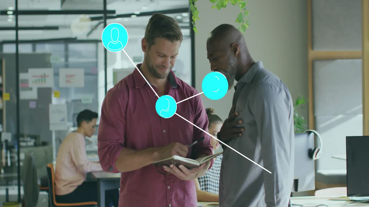 Younger man writing notebook, older man watching, network nodes growing to visualize business links