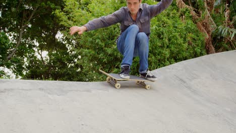 Front-view-of-young-caucasian-man-practicing-skateboarding-trick-on-ramp-in-skateboard-park-4k