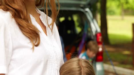 madre e hija sonriendo a la cámara frente al coche