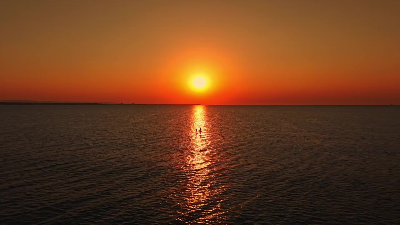 Sunset over the ocean with reflections on the water during evening hours near the shore