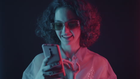 woman using phone under neon light