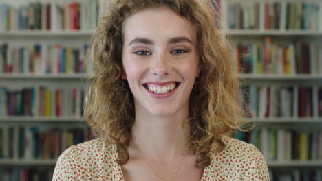 Primer-Plano-Retrato-De-Una-Hermosa-Joven-Estudiante-Pelirroja-Sonriendo-Alegre-A-La-Cámara-En-El-Fondo-De-La-Estantería-De-La-Biblioteca