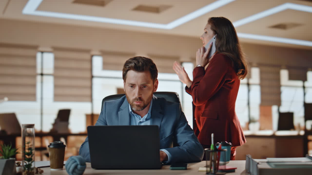 dos compañeros de trabajo ocupados trabajando en una oficina de lujo. equipo resolviendo problemas por teléfono