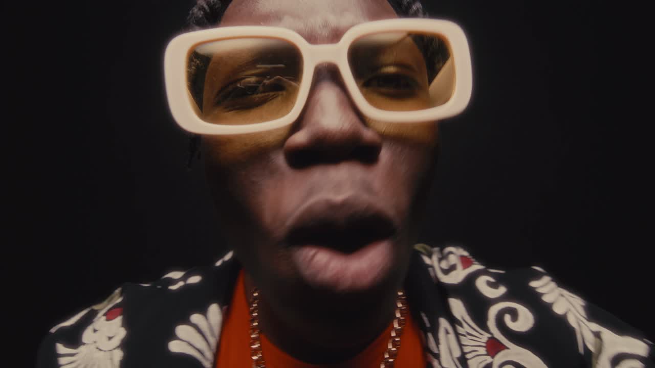 Stylish Black Man Performing Rap Song and Gesturing Energetically to Camera