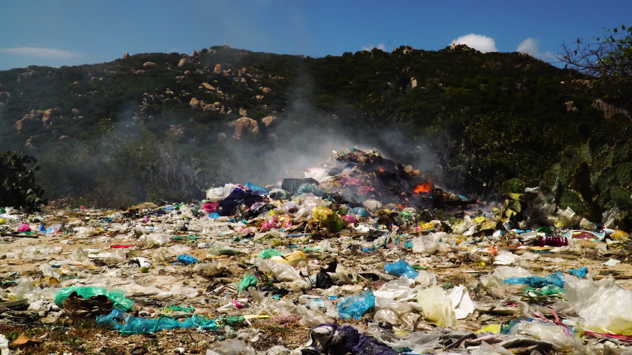 montón de vertederos de basura plástica, residuos de basura quemados en vertederos de basura, contaminación del aire por humo tóxico que libera partículas nocivas para la salud en la atmósfera.