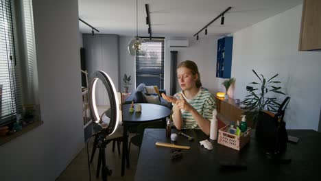 mujer joven haciendo tutorial de maquillaje en casa