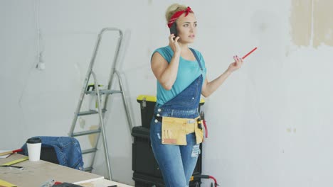 doing home repairs woman talking on smartphone