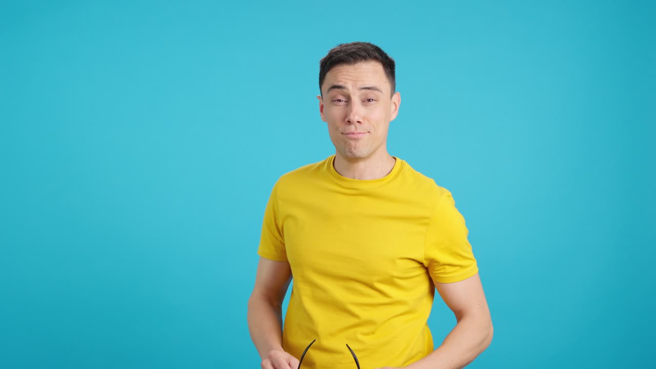 Man in yellow t-shirt against blue background
