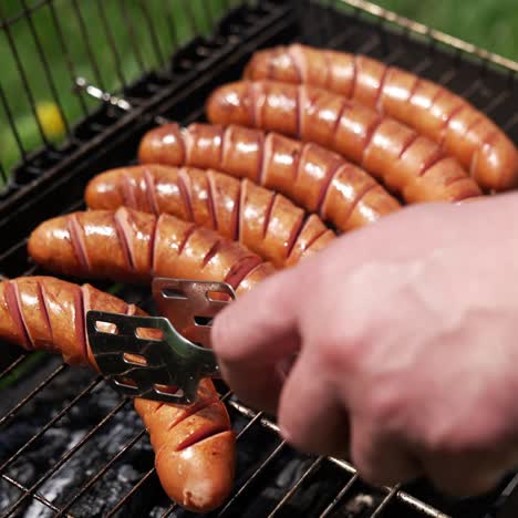 Grilled sausages roasting on barbecue grill outdoors. Grilled food frying and smoking in charcoal grills. Tasty delicious sausages. Street food for picnic and camping