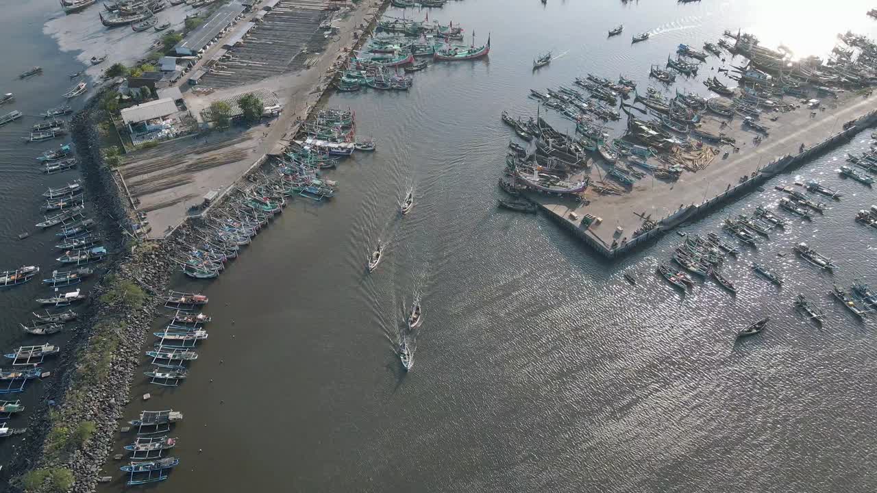 Vibrant footage of numerous fishing boats docked at a bustling harbor, their colorful hulls creating a lively scene. Perfect for themes of maritime life, coastal culture, and local industry