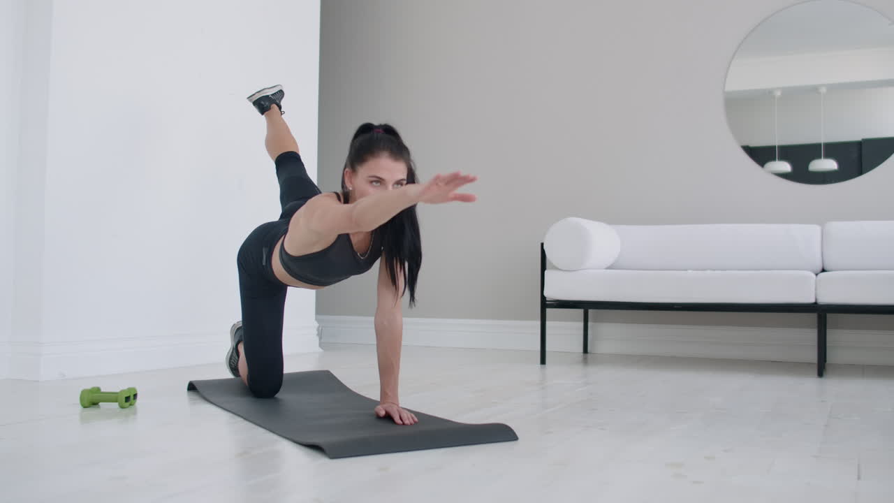 la niña levanta su pierna izquierda y el brazo opuesto alto en sus rodillas