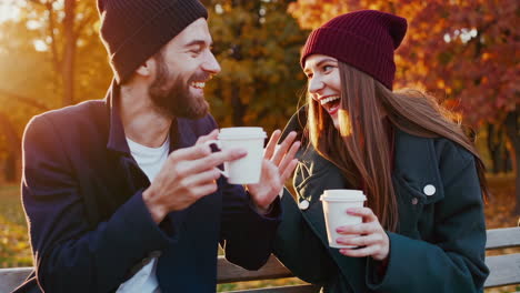 happy couple enjoying coffee and conversation in an autumn park