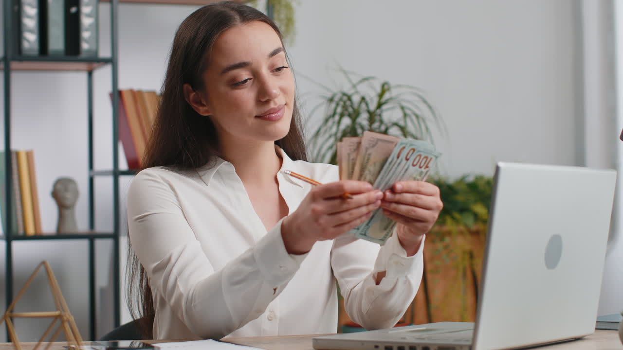 Rich happy business woman working on laptop pc counting money cash calculate earnings income profit